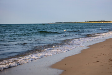 Fototapeta na wymiar Wellen mit weißen Schaum am Strand der Ostsee. 