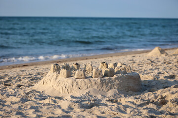 Eine runde große Sandburg am Strand der Ostsee.
