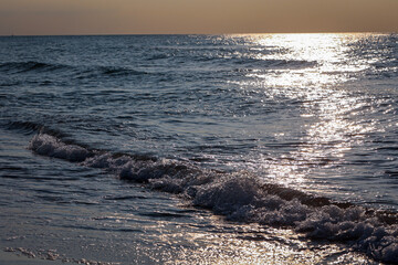 Wellen mit weißen Schaum am Strand der Ostsee.

