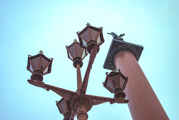 A lantern on the Palace Square and the Alexander Column against the sky in St. Petersburg, Russia.