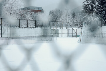 An empty football field in Bulgaria covered in snow. Winter time season. Football gates are empty and white with snow. High quality photo