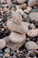 Fototapeta na wymiar Vertical grained photo, soft focus. Pile of gray beach stones