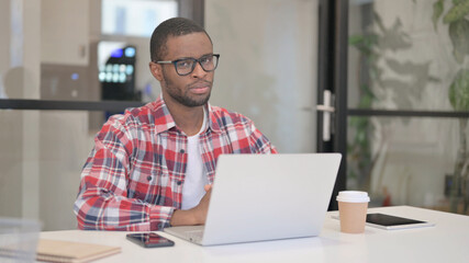 African Man Shaking Head as No Sign while using Laptop