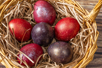 Wicker basket with colorful Easter eggs . close up