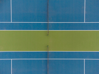 Shooting from a drone. A blue sports field with a dividing yellow stripe and crisp graphics. Sports playground. Healthy lifestyle, active rest, amateur and professional sports. Abstraction.