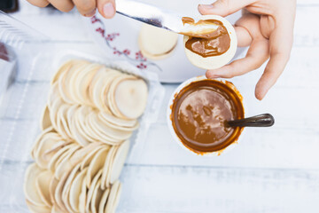 Young woman's hans preparing alfajores. Latin food.