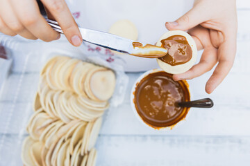 Young woman's hans preparing alfajores. Latin food.