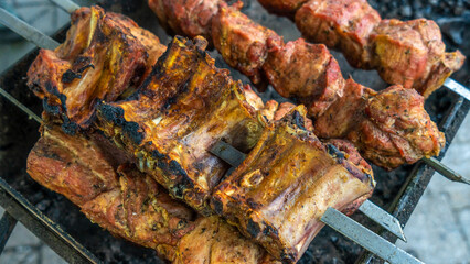 Tasty food roasting on skewers. Delicious bbq kebab grilling on open grill. Outdoor kitchen. Food festival in city.