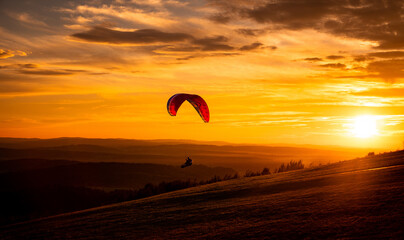 Paralotnia na Bieszczadzkim niebem o zachodzie słońca.  Paraglider in the Bieszczady sky at sunset. - obrazy, fototapety, plakaty