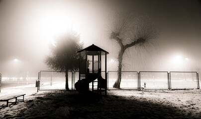 Plac zabaw we mgle zimową porą. Playground in fog during winter time.