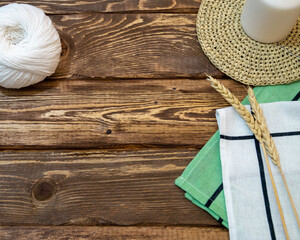 dark wooden boards on which there is a ball of knitting threads, a candle, spikelets of wheat and...