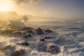 Seascape. Waves beating against the rocks in Quintanilla beach at sunset. Arucas. Canary Islands