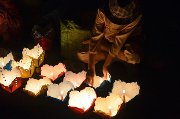 A boy helps her mother sell candles for a special event