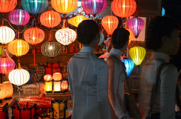 Ladies wearing Vietnamese traditional costumes at a Lantern shops 
