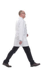 mature doctor in a white coat striding forward