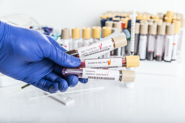 Researcher with blood sample of New Variant of the Covid-19 DELTACRON and generic data of covid-19 Coronavirus Mutations. Doctor in analysis lab holding sample of new strain of covid DELTACRON.