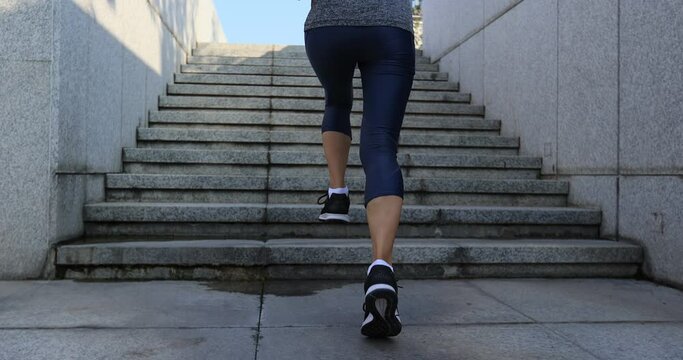 Fitness sports woman running up stairs in city
