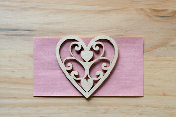 wood heart shape and pink paper on wood