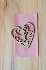 fancy wooden heart shape on pink paper and wood