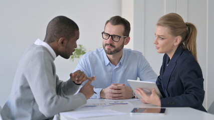 Business People using Tablet While Preparing Reports
