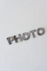 the word "photo" in painted felt type letters on a light background