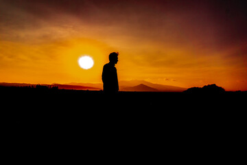 silhouette of a person standing on a rock