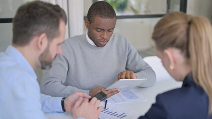 Fototapeta premium Business People using Tablet and Smartphone during Discussion