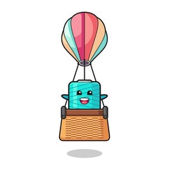 yarn spool mascot riding a hot air balloon