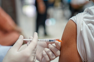 Obraz na płótnie Canvas Close up of a Doctor making a vaccination in the shoulder of patient, Flu influenza vaccine clinical trials concept, corona virus treatment side effect, inoculation.