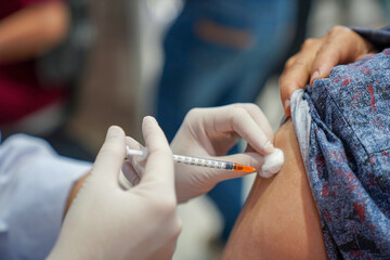 Close up of a Doctor making a vaccination in the shoulder of patient, Flu influenza vaccine clinical trials concept, corona virus treatment side effect, inoculation.
