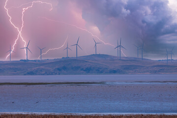 Photograph of Wind Turbines on a hill during a lightning storm