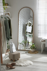 Fototapeta na wymiar Rack with different stylish clothes, shoes and decorative elements in dressing room. Interior design