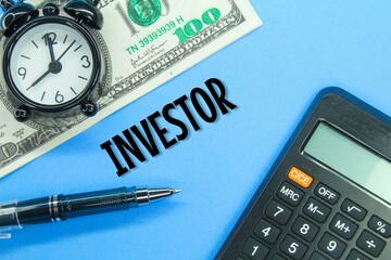 calculators, alarm clocks, banknotes and pens with the word investor
