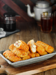 risoles sosis or mayonnaise sausage rissole is a small patty rolled in breadcrumbs it is filled with mayonnaise, boiled egg and sausage. Served on gray plate.