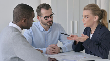 Businesswoman Explaining Documents to Male Colleagues