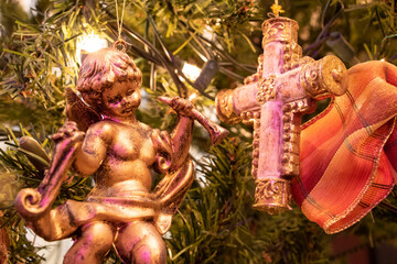 ツリーに吊るした金色の天使と十字架のクリスマスツリーオーナメントのクローズアップ