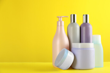 Many different cosmetic products on yellow background. Space for text
