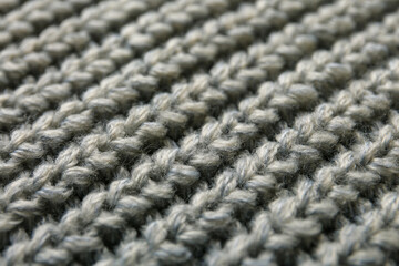 Beautiful grey knitted fabric as background, closeup