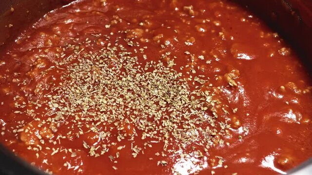 Sprinkling Oregano Spice into Simmering Pasta Bolognese Sauce, Seasoning Sauce - Steady Shot