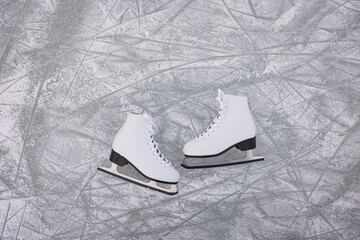 Pair of figure skates on ice, flat lay