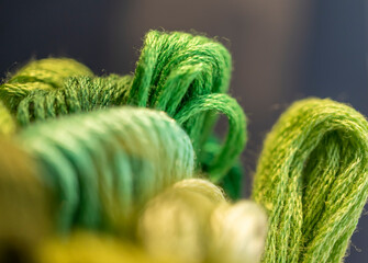 detalle de conjunto de madejas de hilos para bordar color verde con desenfoque