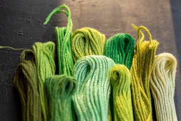 detalle de conjunto de madejas de hilos para bordar color verde con desenfoque