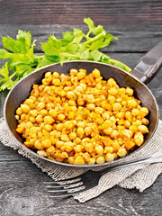 Chickpeas stewed with vegetables in pan on black board