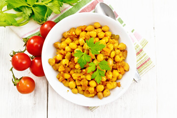 Chickpeas stewed with vegetables in plate on board top