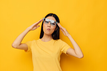 cheerful woman in yellow t-shirt and stylish glasses posing fashion