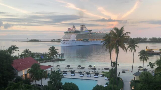 Massive cruise ship docking at Bahamas port, static view from a balcony of a hotel, tropical island resort with pool and palm trees, Nassau 4K 30 FPS