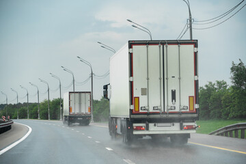 Trucks are driving on the highway in the rain