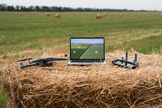 Laptop and drone on the field. Smart farming and agriculture digitalization