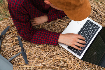 Farmer with laptop and drone on the field. Smart farming and agriculture digitalization