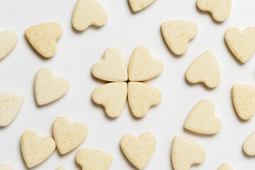 Valentine minimalistic greeting card, scattered heart-shaped sweet little cookies on white